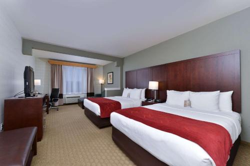 a hotel room with two beds and a flat screen tv at Comfort Suites Airport Tukwila Seattle in Tukwila