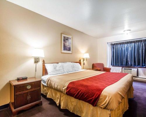 a hotel room with a bed and a window at Rodeway Inn & Suites Madison East in Madison