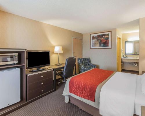 a hotel room with a bed and a desk with a television at Comfort Inn On the Bay in Port Orchard
