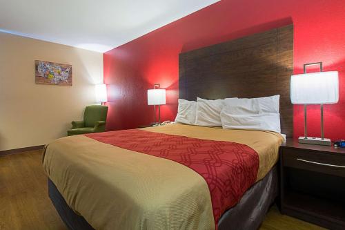a hotel room with a bed with a red wall at Econo Lodge in Buckley