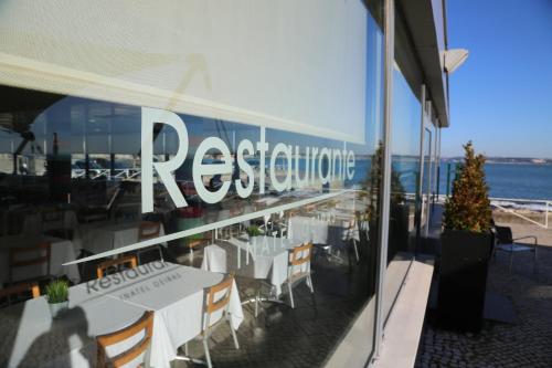 a restaurant with a reflection of the ocean in the window at INATEL Oeiras in Oeiras