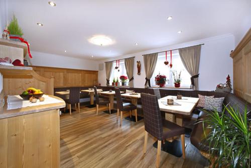 a restaurant with tables and chairs in a room at Villa Seceda in Selva di Val Gardena