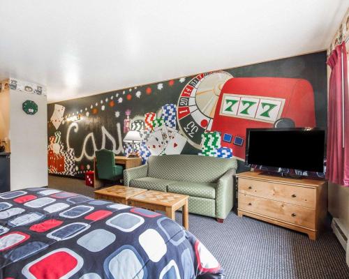 a bedroom with a bed and a wall with a painting at Rodeway Inn & Suites Madison East in Madison