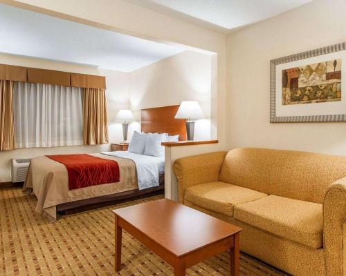a hotel room with a bed and a couch at Quality Inn & Suites in Eau Claire