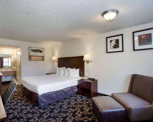 a hotel room with a bed and a chair at MorningGlory Inn & Suites in Bellingham