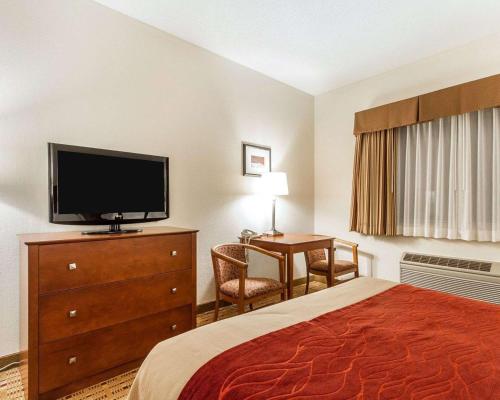 a hotel room with a bed and a flat screen tv at Quality Inn & Suites in Eau Claire