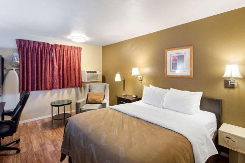 a hotel room with a bed and a chair at Quality Inn in Moses Lake