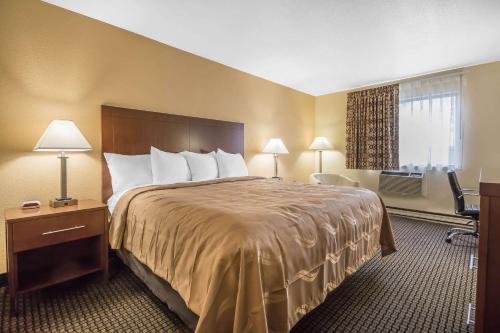 ein Hotelzimmer mit einem großen Bett und einem Fenster in der Unterkunft Quality Inn in Janesville