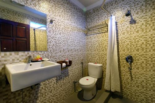 ein Badezimmer mit einem Waschbecken, einem WC und einem Spiegel in der Unterkunft Segara Anak Hotel in Kuta Lombok