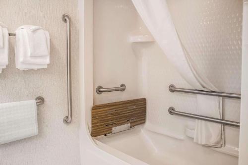 a bathroom with a bath tub with a mirror at Rodeway Inn Abbotsford in Abbotsford