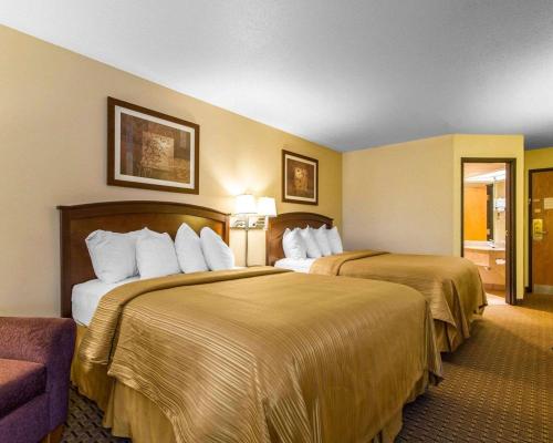 a hotel room with two beds and a couch at Quality Inn La Crosse North in La Crosse