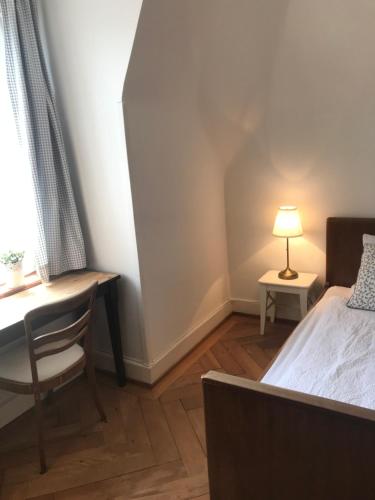 a bedroom with a bed and a desk and a lamp at The Bed + Breakfast in Luzern