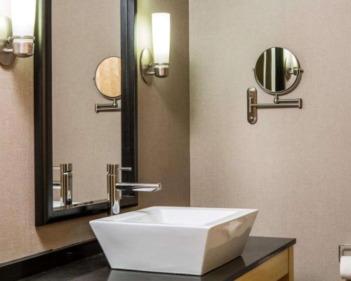 La salle de bains est pourvue d'un lavabo blanc et d'un miroir. dans l'établissement Cambria Hotel Appleton, à Appleton