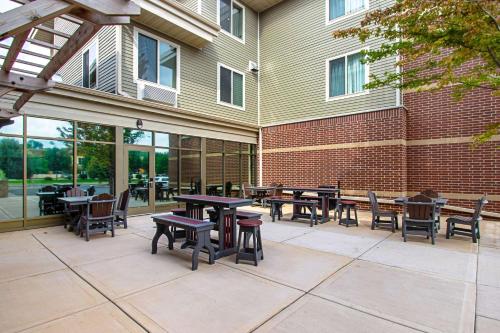 a patio with tables and chairs and a building at Sleep Inn & Suites Madison - Monona in Madison