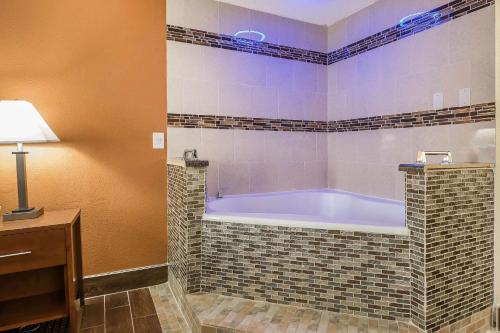 a large bathroom with a tub in a room at Quality Inn in Janesville