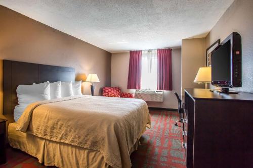 a hotel room with a bed and a flat screen tv at Quality Inn & Suites in West Bend