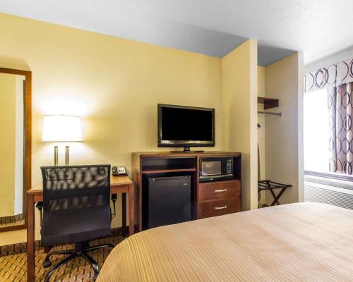 a hotel room with a bed and a flat screen tv at Quality Inn La Crosse North in La Crosse