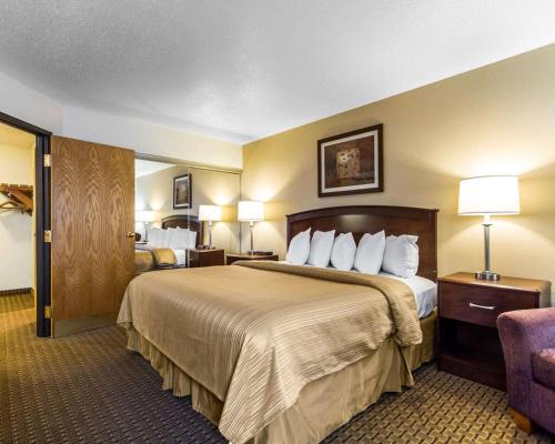 a hotel room with a large bed and a chair at Quality Inn La Crosse North in La Crosse