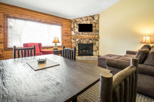a living room with a wooden table and a fireplace at Bluegreen Vacations Christmas Mountain Village, an Ascend Collection Resort in Wisconsin Dells