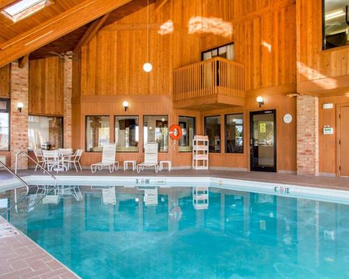 a large swimming pool with chairs and tables in a building at Quality Inn & Suites Kimberly - Appleton East in Kimberly