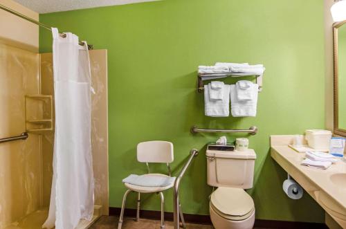 a bathroom with a toilet and a green wall at Quality Inn Summersville in Summersville
