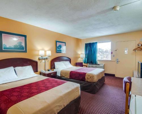 a hotel room with two beds and a television at Econo Lodge Near Bluefield College in Bluefield