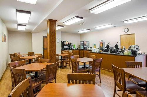 an empty restaurant with wooden tables and chairs at Quality Inn Summersville - New River Area in Summersville