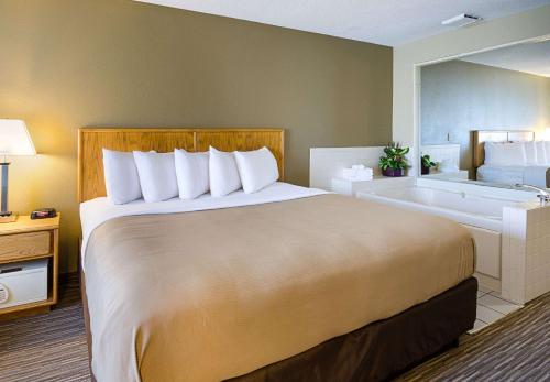a hotel room with a bed and a bath tub at Quality Inn in Princeton