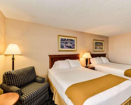 a hotel room with two beds and a chair at Quality Inn Spring Mills - Martinsburg North in Martinsburg
