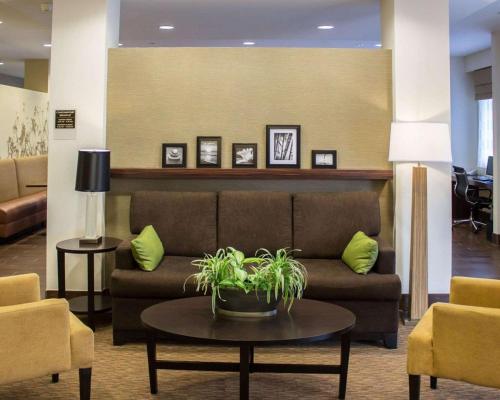 a lobby with a couch and a table and chairs at Sleep Inn & Suites Moundsville - Wheeling in Moundsville