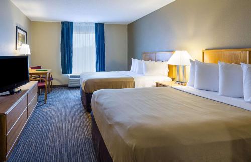 a hotel room with two beds and a flat screen tv at Quality Inn in Princeton