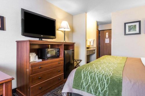 a hotel room with a bed and a flat screen tv at Comfort Inn in Weirton
