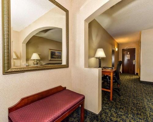 a hotel room with a bench and a mirror at Quality Inn Spring Mills - Martinsburg North in Martinsburg