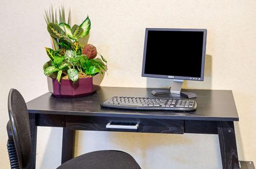 a desk with a computer and a plant on it at Quality Inn in Princeton