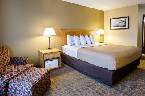 Habitación de hotel con cama y silla en Quality Inn, en Princeton