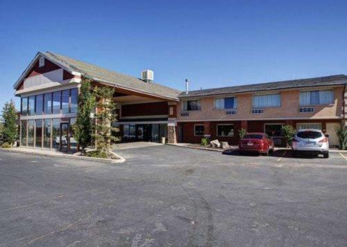 Un gran edificio con coches aparcados en un estacionamiento. en Quality Inn Evanston near Wyoming Downs, en Evanston