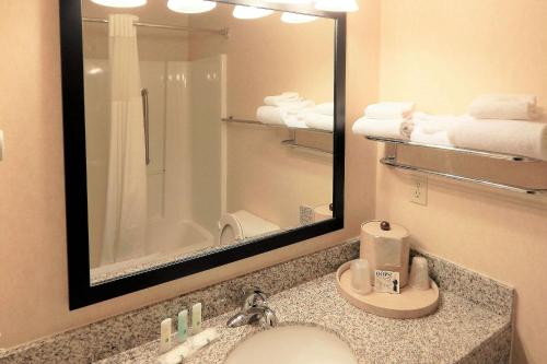 a bathroom with a sink and a mirror and towels at Quality Inn Sheridan in Sheridan