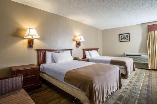 una habitación de hotel con dos camas y un sofá en Rodeway Inn Cheyenne I-80 East, en Cheyenne