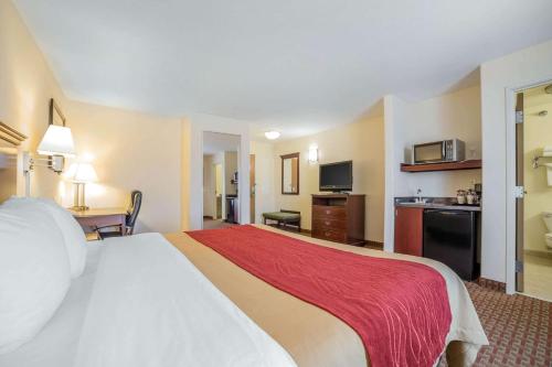 a hotel room with a large bed with a red blanket at Comfort Inn & Suites Rock Springs-Green River in Rock Springs