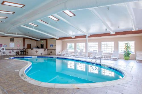 a large pool in a large room with chairs at Quality Inn & Suites University in Laramie