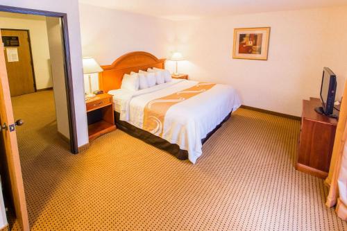 a hotel room with a bed and a television at Quality Inn & Suites University in Laramie