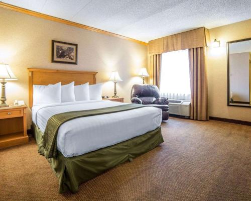 a hotel room with a large bed and a chair at Quality Inn & Suites Casper near Event Center in Casper
