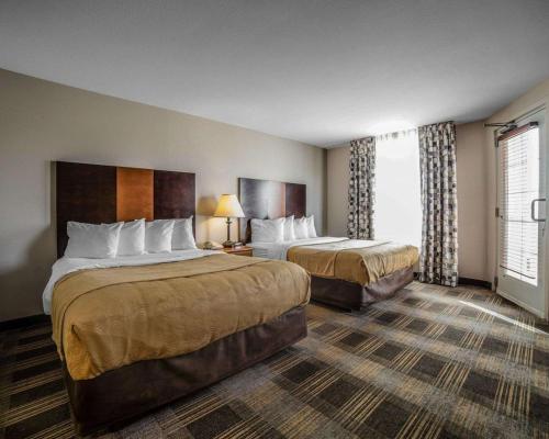 a hotel room with two beds and a window at MainStay Suites Casper in Casper