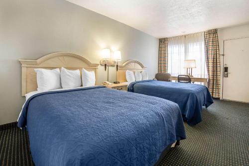 a hotel room with two beds with blue sheets at Quality Inn Rock Springs in Rock Springs