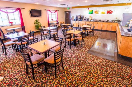 a restaurant with tables and chairs and a bar at Quality Inn & Suites University in Laramie
