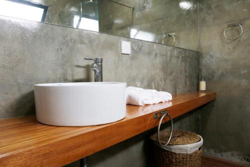 a bathroom with a white sink on a wooden counter at Mitós Vila 3 in Ribeira Grande