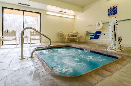 a hot tub in a waiting room with a table and chairs at Quality Inn & Suites Manhattan in Manhattan