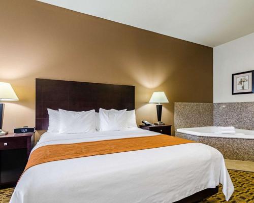 a hotel room with a large bed with white pillows at Comfort Inn & Suites Lawrence - University Area in Lawrence