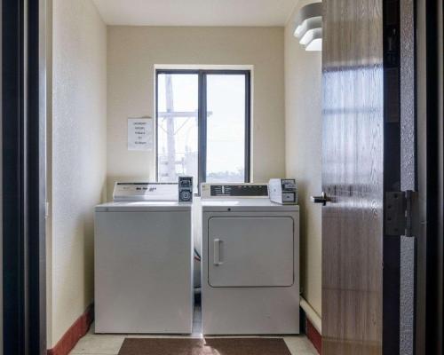 a small kitchen with a refrigerator and a window at Quality Inn I-70 at Wanamaker in Topeka