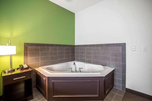 baño con bañera y pared verde en Sleep Inn & Suites Haysville, en Haysville